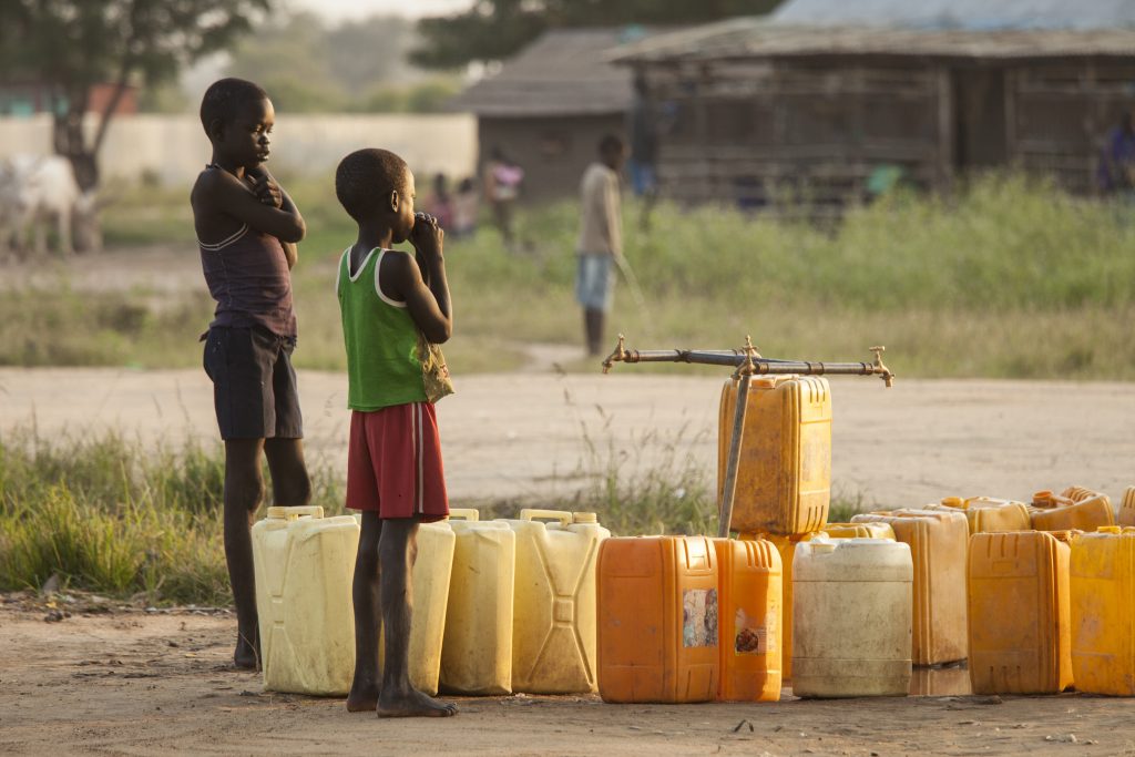 Bild: Jugendliche warten auf das Befüllen von Wasserkanistern im Südsudan. (John Wollwerth / Shutterstock.com)