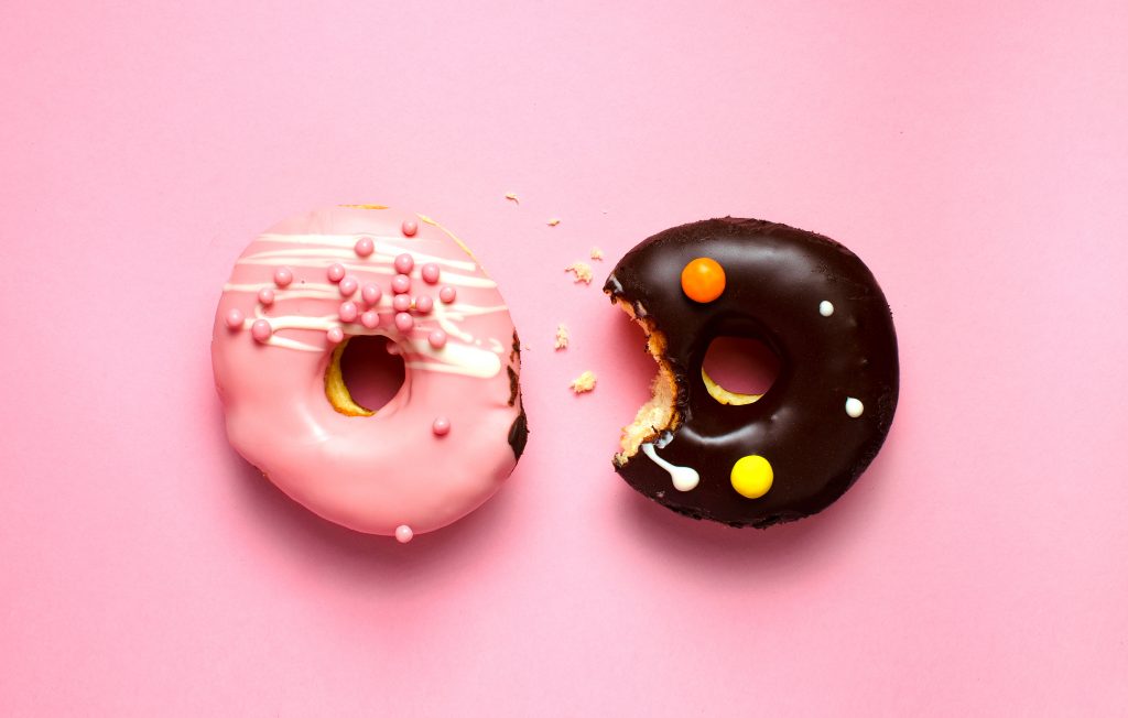 Donuts with icing on pink background. Sweet donuts. Donuts background . Eaten donut.