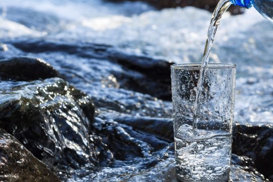 Ein Glas Wasser neben einem Fluss
