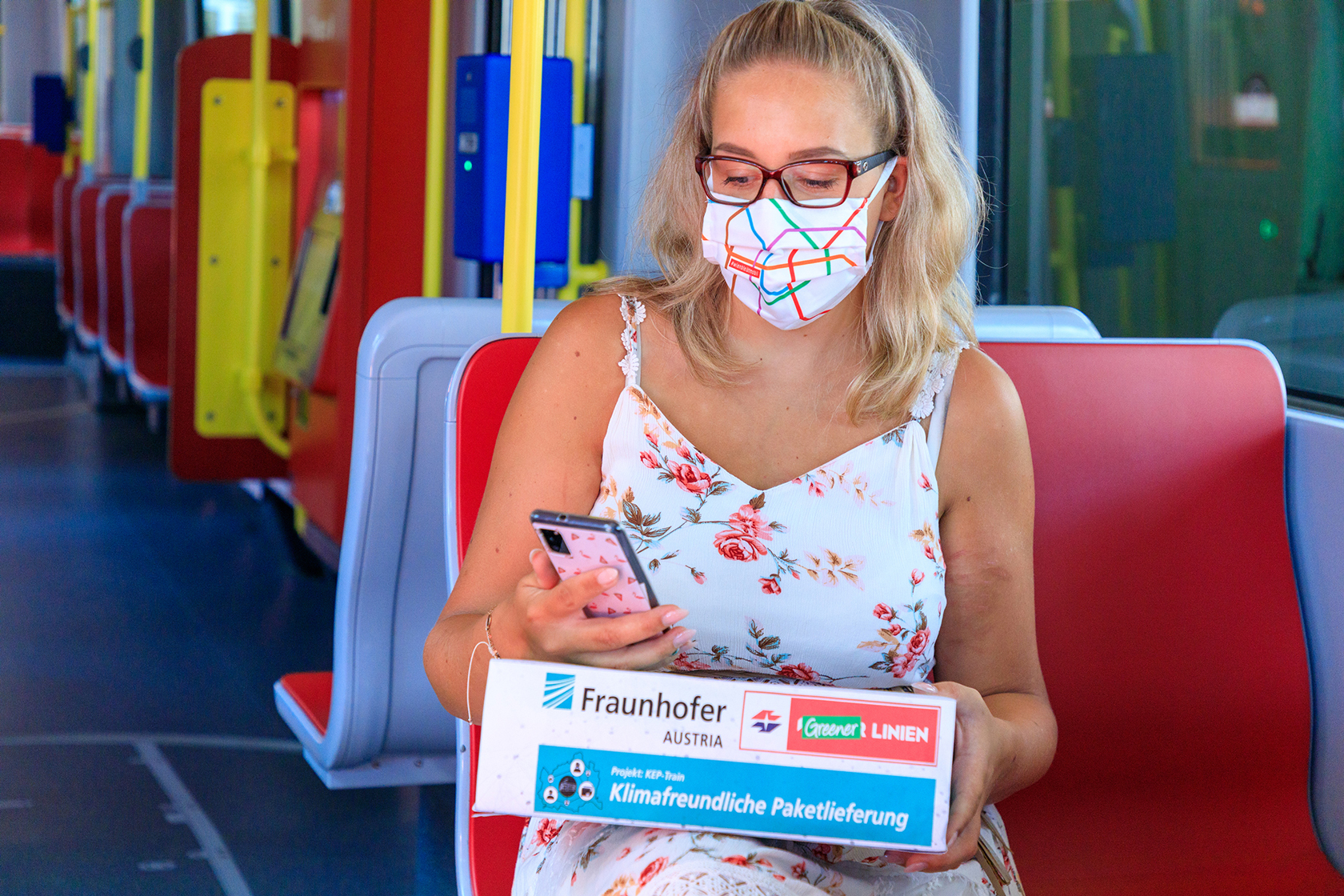 Ein Fahrgast nimmt in der Straßenbahn ein Paket mit