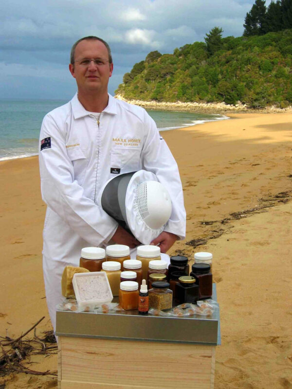 Ein Foto von Berhard Schneider mit Gläsern seines Manukahonigs.