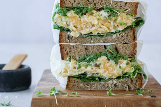 Man sieht zwei gestapelte belegte Brote mit Eiersalat.
