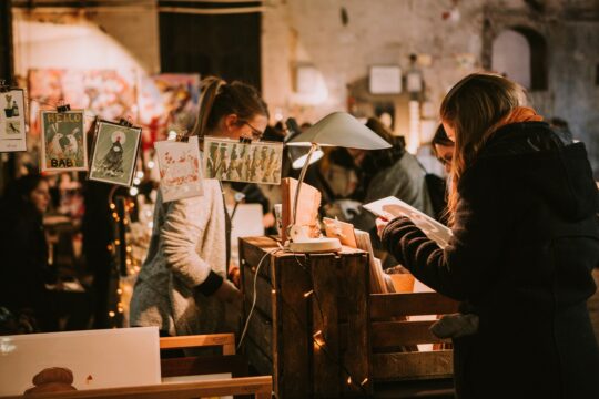 Zu sehen sind mehrere Menschen in einer Markthalle.