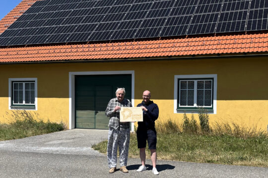 Ein Haus mit Photovoltaik-Panelen am Dach.