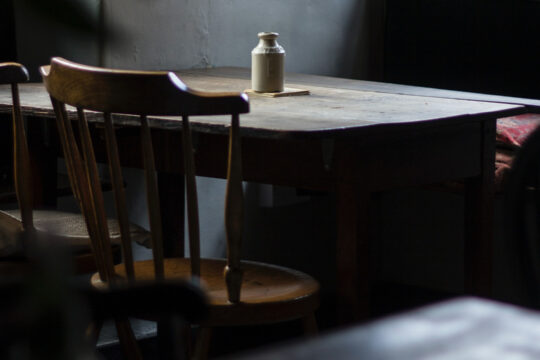 Ein leerer Tisch mit alten Stühlen