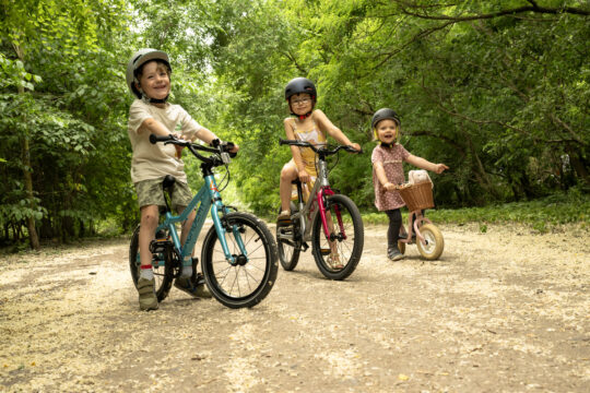 Drei Kinder auf Rädern.