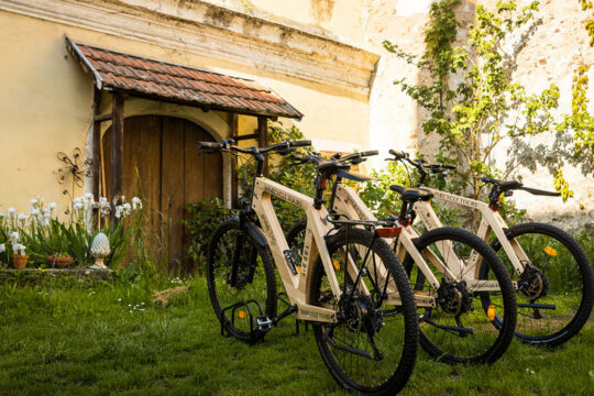 Mehrere Räder die in einem Radständer vor einem Haus stehen.
