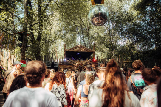 Menschen, die auf einem Festival im Wald tanzen.