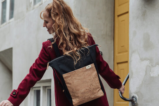 Eine Person von hinten die einen Rucksack trägt.