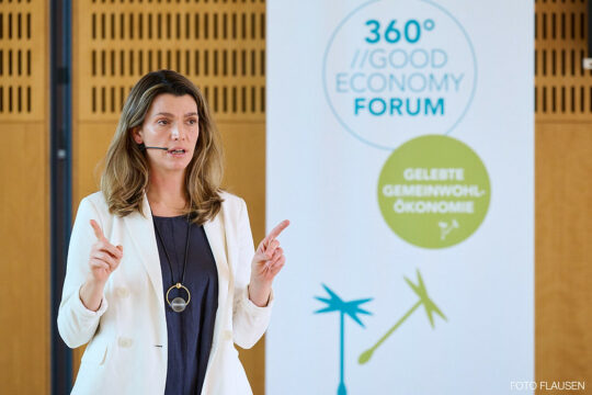 Eine Person spricht auf einer Bühne.