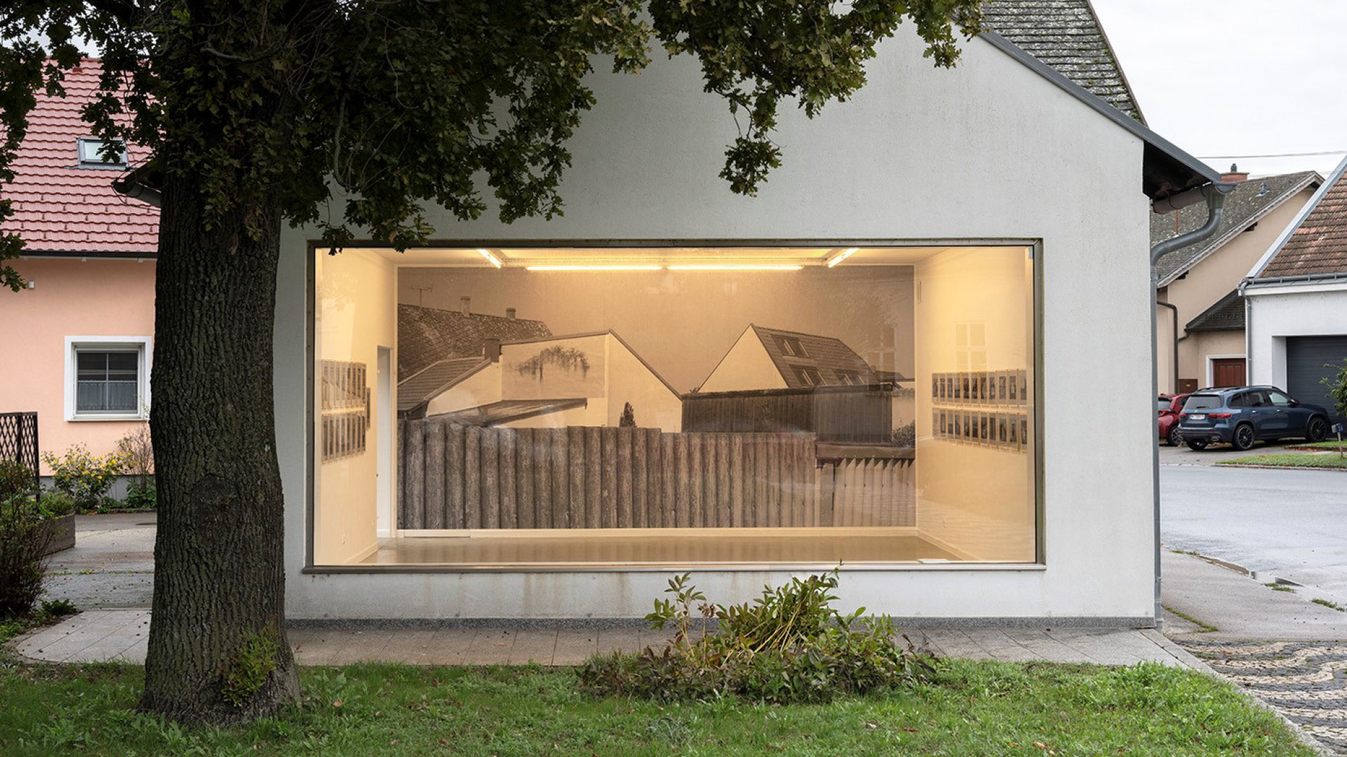 Ein kleines Haus mit einer Glaswand, durch die man ins Innere sehen kann. Dort ist eine Ausstellung.