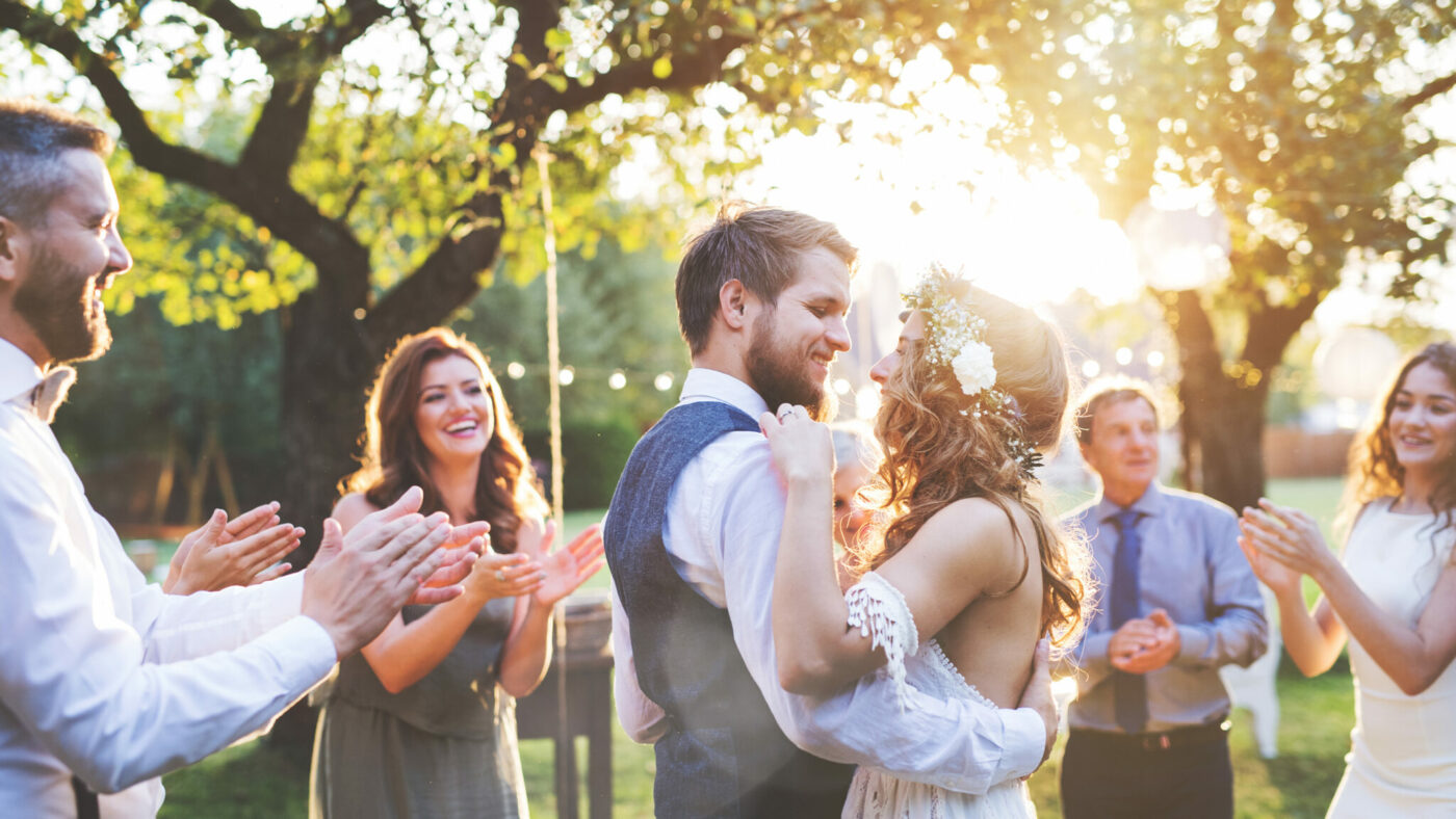 Zwei Menschen tanzen auf einer Hochzeit im Freien.