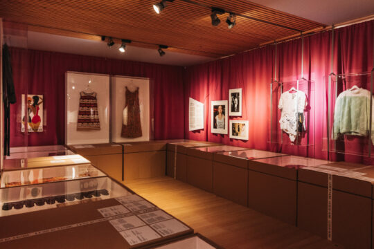 Ein Raum in dem mehrere Ausstellungsobjekte die mit Mode zu tun haben ausgestellt sind.