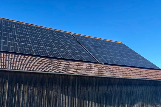 Mehrere Photovoltaik-Panele auf einem Dach.