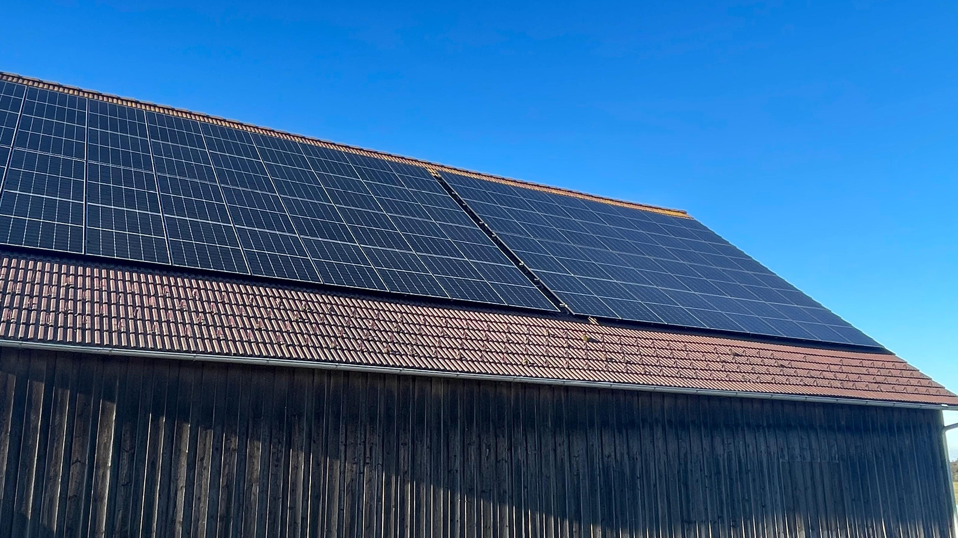 Mehrere Photovoltaik-Panele auf einem Dach.