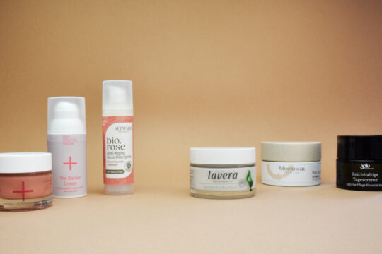 Mehrere Feuchtigkeitscremen vor beigem Hintergrund.